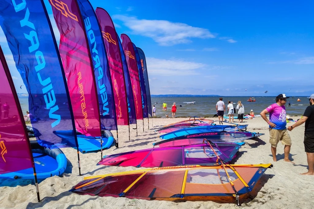 Najnowsze żagle NeilPryde na plaży wzdłuż flag