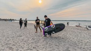 Maciek walks through the beach with JP Hydrofoil Slalom