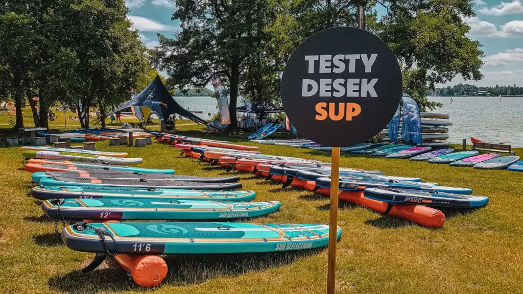 SUP boards laying on the grass near the lake